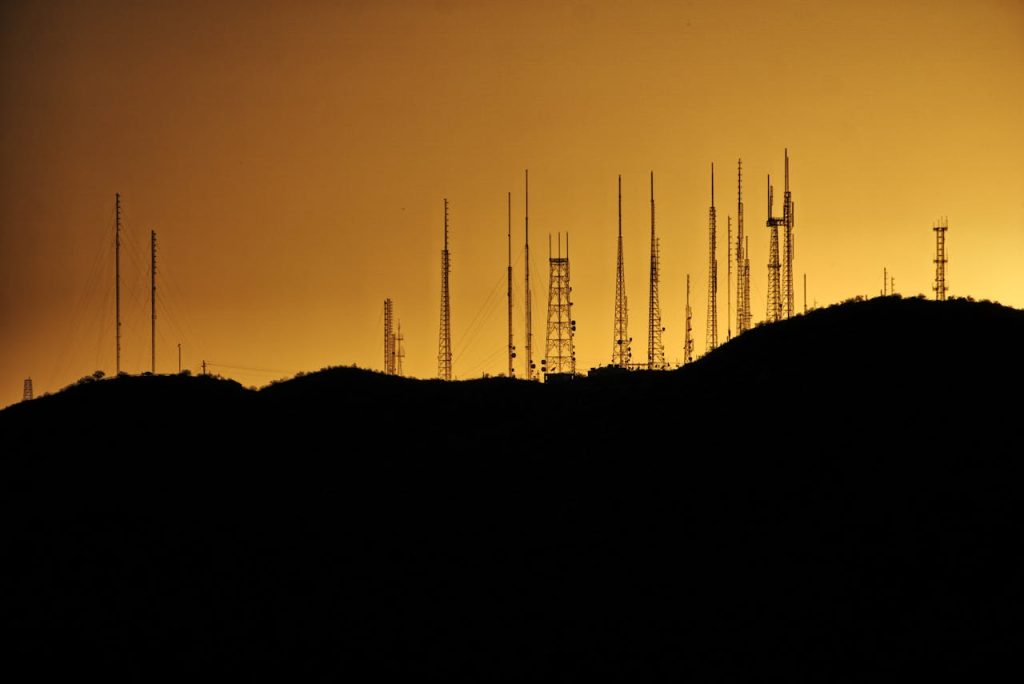 Silhouette of communication towers on a hill at sunset in Phoenix, Arizona.